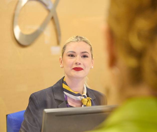 Employee helping a traveller in info kiosk at Athens International Airport