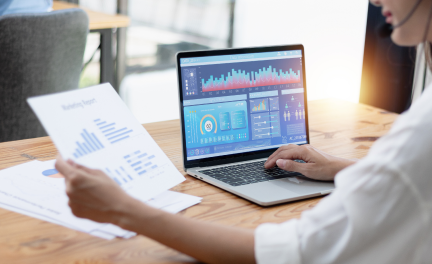 Employee working in laptop with financial documents