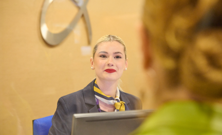 Employee helping a traveller in info kiosk at Athens International Airport