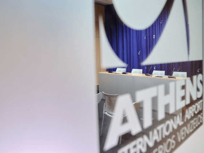 Glass door with the Athens International Airport logo