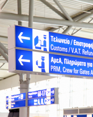 Signage showing customs and tax refund directions in Athens International Airport