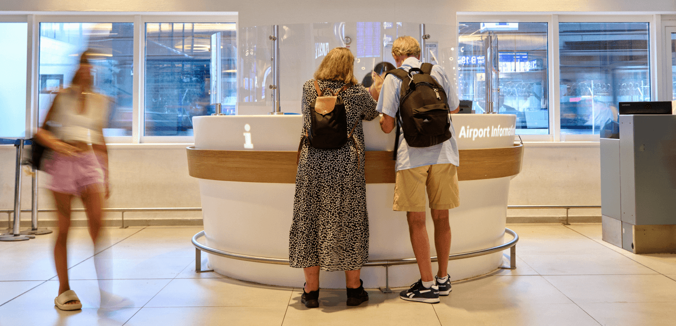 Travelers at the information desk at Athens International Airport