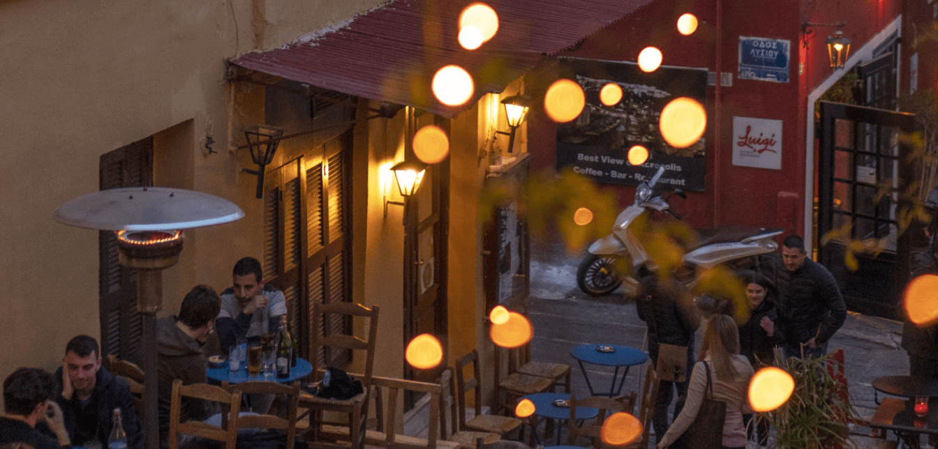 People enjoying evening drinks at a bar in the Plaka area of Athens