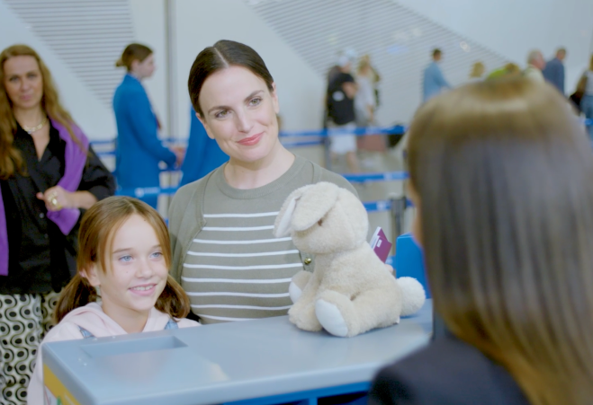 Mother and children interacting with airport staff at Athens International Airport